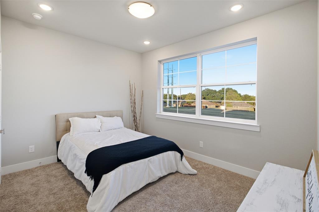 Neutral-toned interior featuring wall-to-wall carpeting, recessed ceiling lighting, and a large multi-pane window with a sill