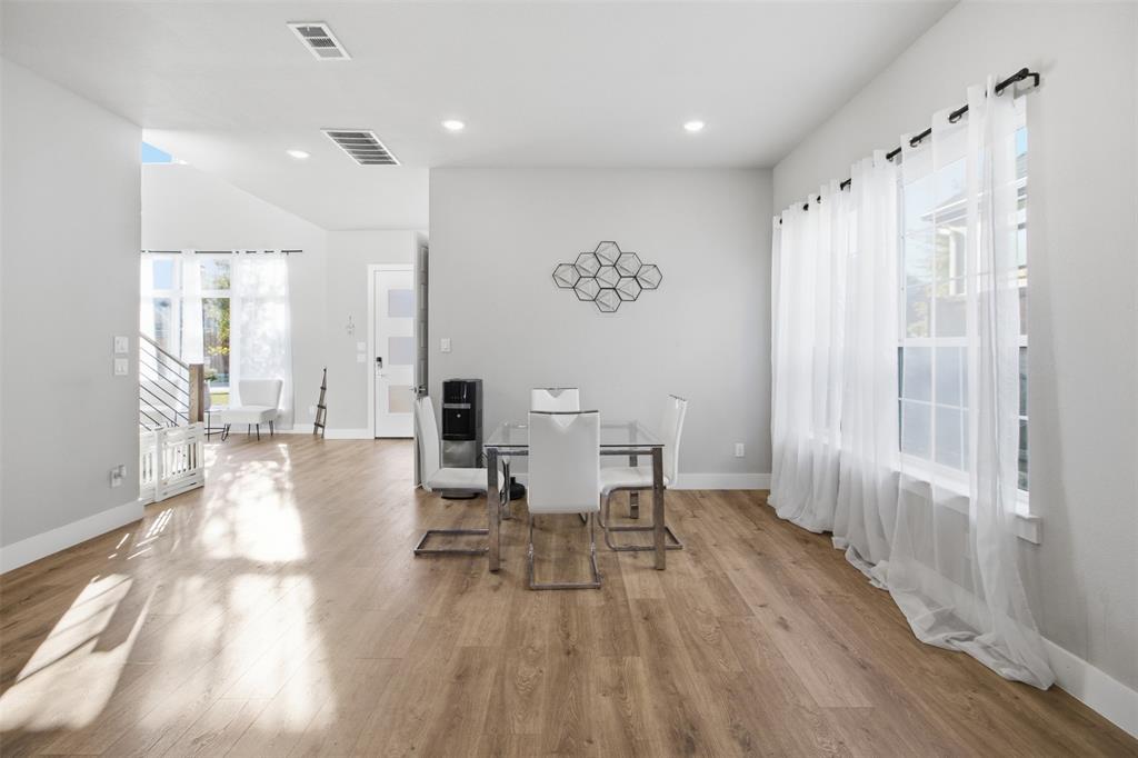 Open-concept interior featuring wood-finish flooring, recessed lighting, and large windows with horizontal muntins