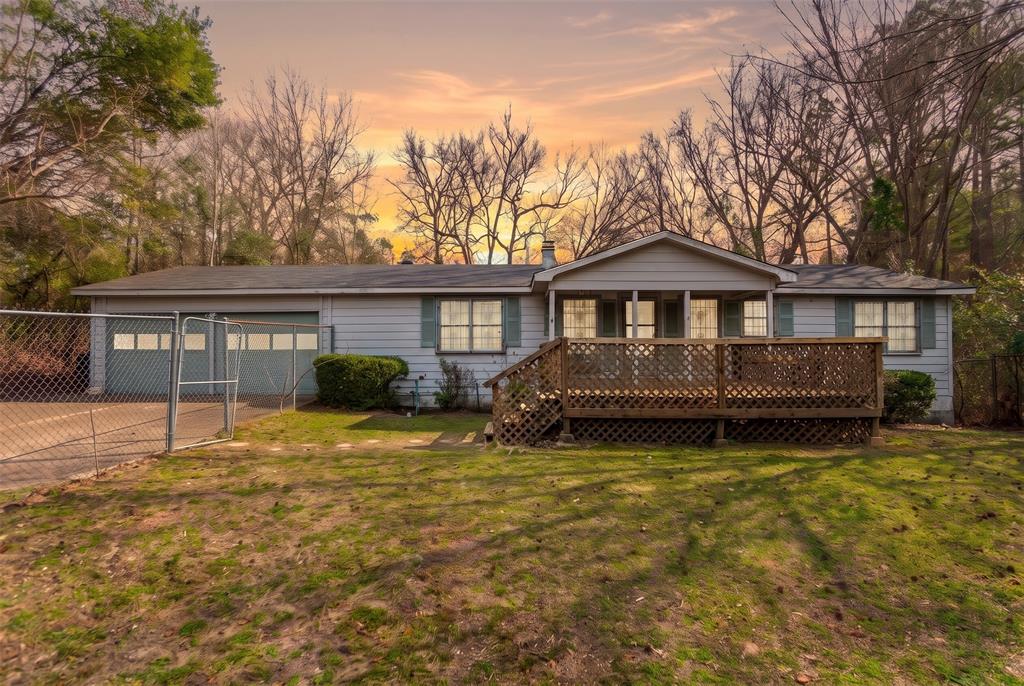 Single-story residence featuring horizontal siding, a covered front porch with lattice skirting, and an attached two-car garage Single-story residence featuring horizontal siding, a covered front porch with lattice skirting, and an attached two-car garage