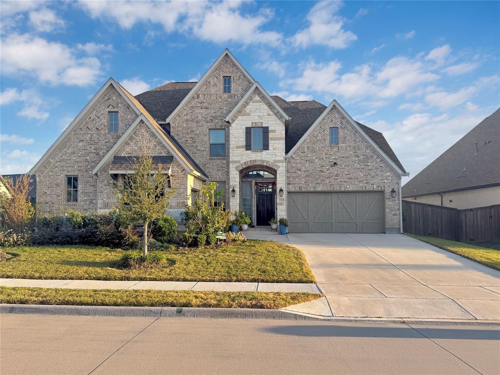 Multi-gabled brick and stone facade featuring an arched entryway, decorative wooden shutters, and an attached three-car garage