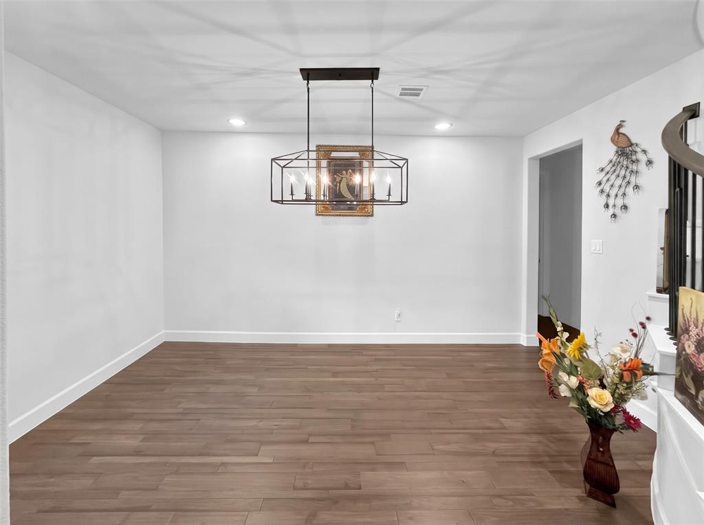 Geometric metal chandelier with six candelabra-style bulbs, wood-finish flooring, and recessed ceiling lighting