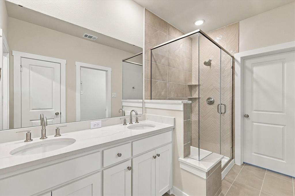 Master bath dual sinks. Walkin shower with sitting. Wall tile up to the ceiling