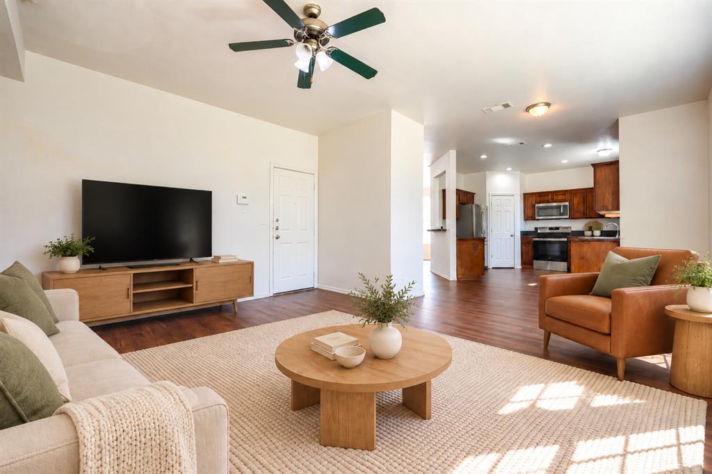 Living area featuring wood-finish flooring, a ceiling fan with integrated lighting, and recessed ceiling lighting