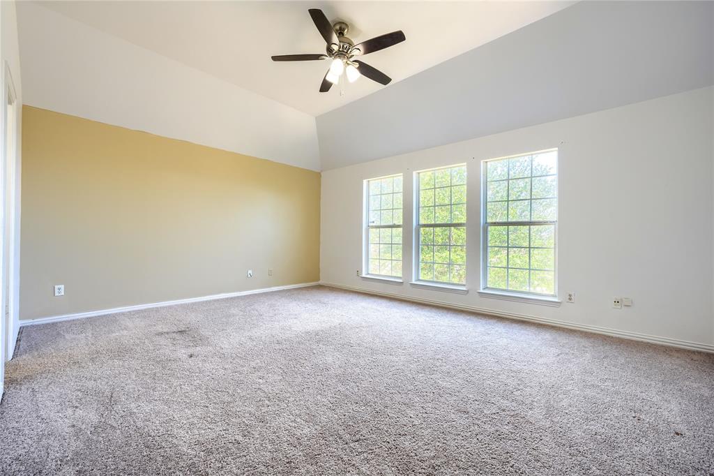 Vaulted ceilings featuring a three-light ceiling fan and three large multi-pane windows