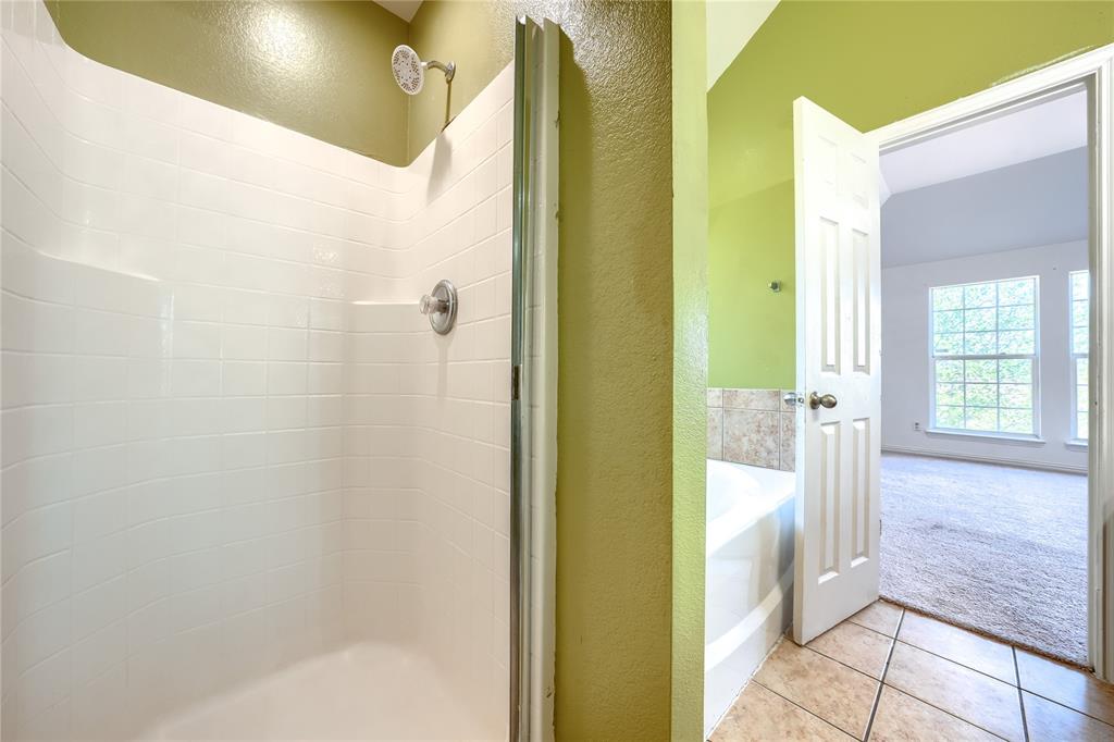 Walk-in shower with white tile surround, chrome fixtures, soaking tub with tile deck, and ceramic tile flooring