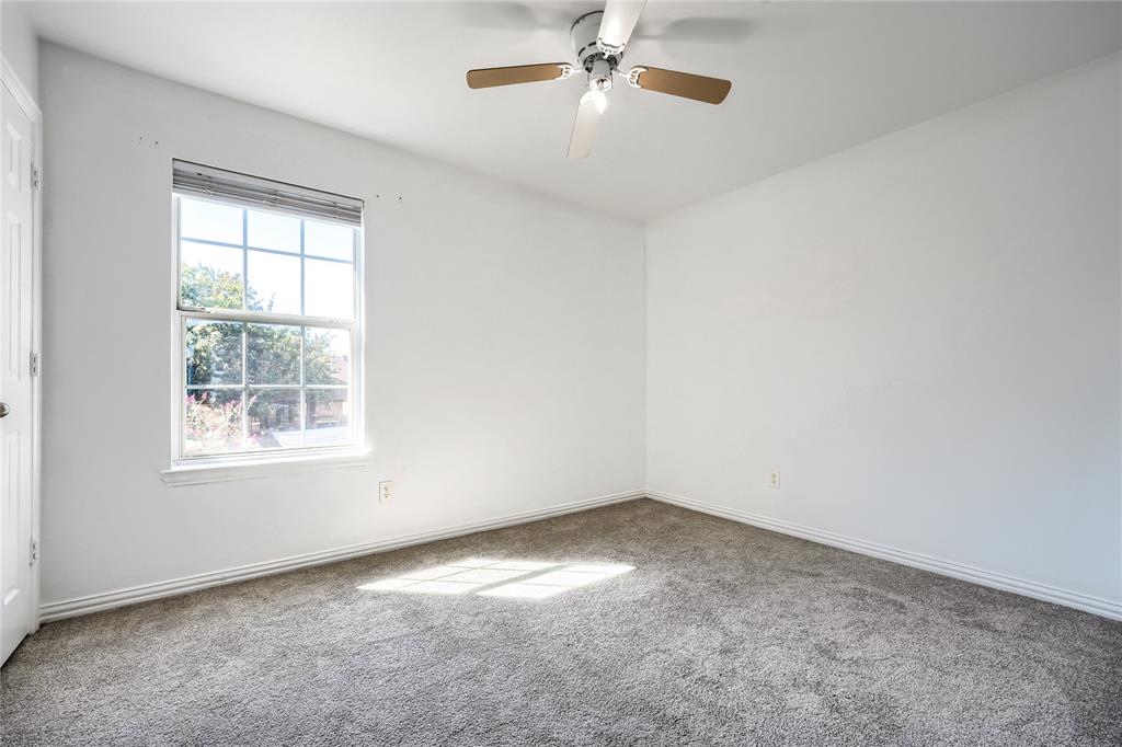 Neutral-toned wall-to-wall carpeting, multi-pane window with integral blinds, and overhead ceiling fan with light fixture