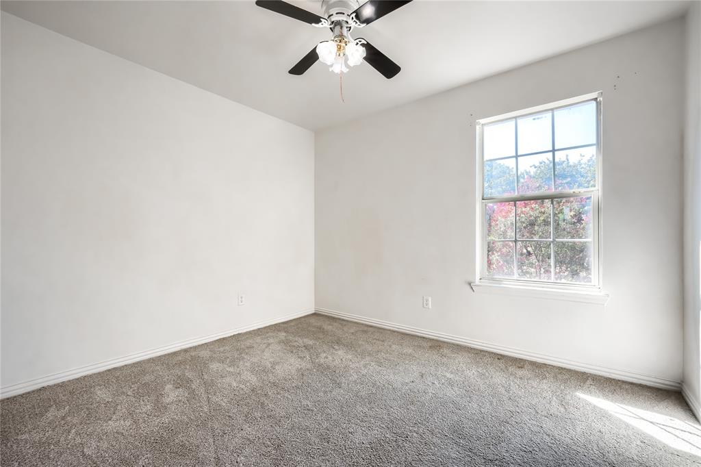 Neutral-toned wall-to-wall carpeting, multi-pane window with natural light, and ceiling-mounted light fixture with fan
