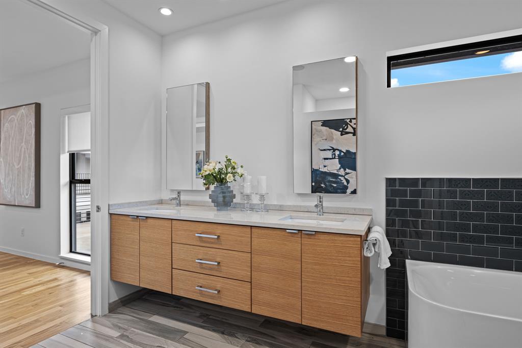 A floating double vanity pairs warm wood cabinetry with a clean, modern finish.