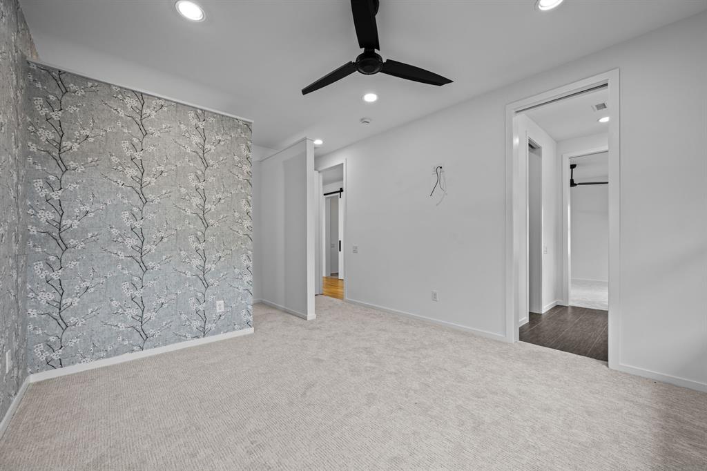 A fourth bedroom with an accent wall and shared bath access offers room for guests, work, or everyday living.