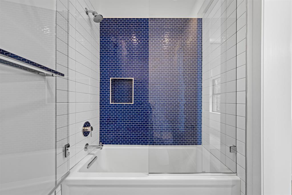 A vivid blue tile accent brings personality to the shared tub-and-shower bath.