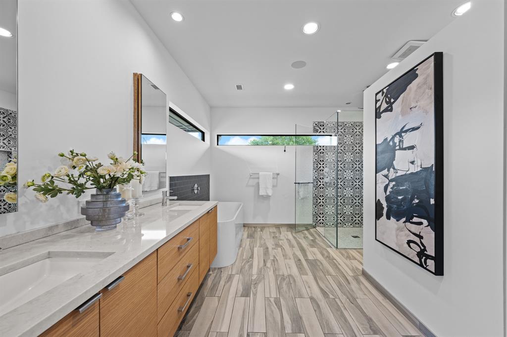 Clerestory windows, a soaking tub, and a glass-enclosed shower create a bright primary bath retreat.