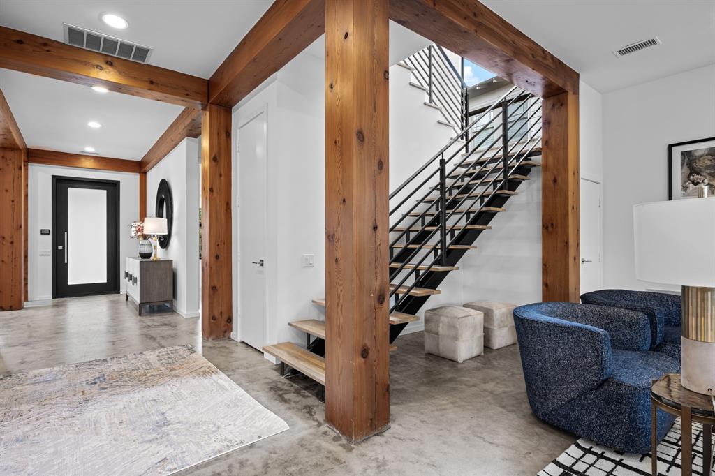Open wood beams and columns and black metal railings turn the staircase into an architectural centerpiece.