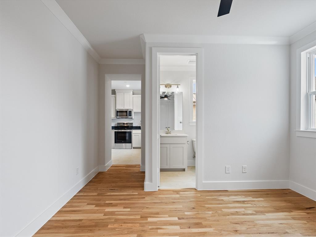 Interior space featuring wood-finish flooring, crown molding, and a neutral color palette