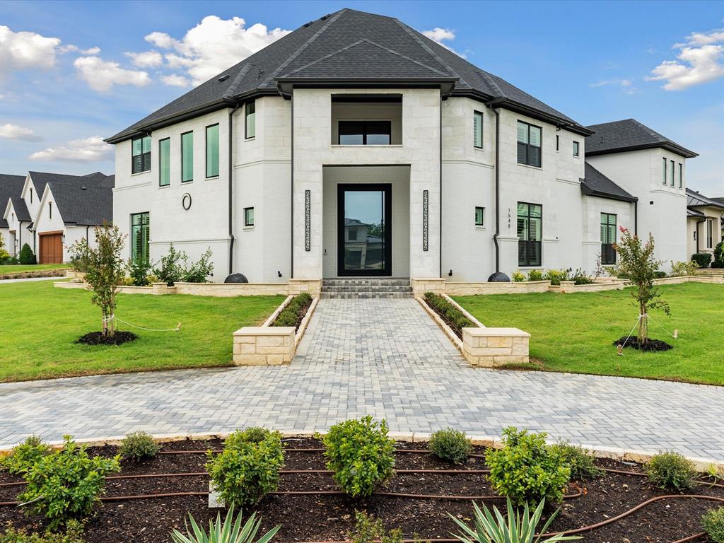 Custom masonry exterior featuring stone facade, multi-faceted roofline, pavers walkway, covered entryway, and multi-pane dark-framed windows Custom masonry exterior featuring stone facade, multi-faceted roofline, pavers walkway, covered entryway, and multi-pane dark-framed windows