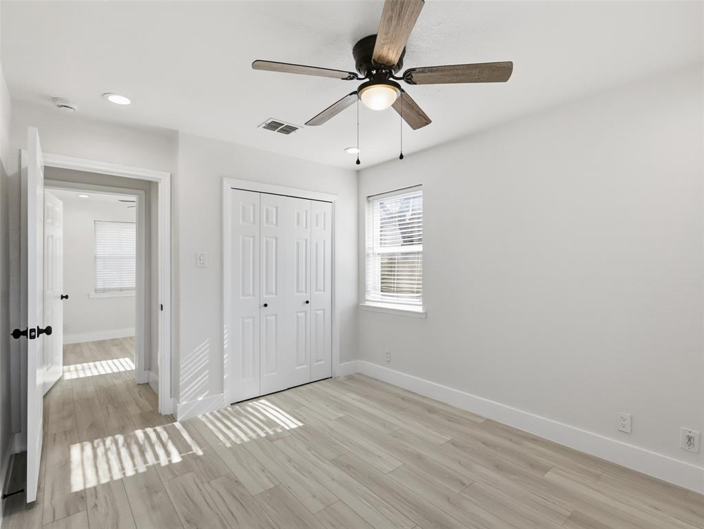 Neutral wall paint, wood-finish flooring, ceiling fan with integrated lighting, recessed lighting, and white six-panel closet doors