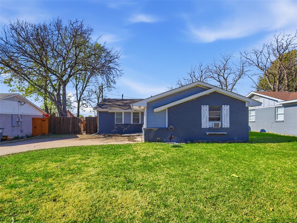 Single-story residence featuring a painted brick exterior, gabled roofline, decorative window shutters, and a concrete driveway Single-story residence featuring a painted brick exterior, gabled roofline, decorative window shutters, and a concrete driveway
