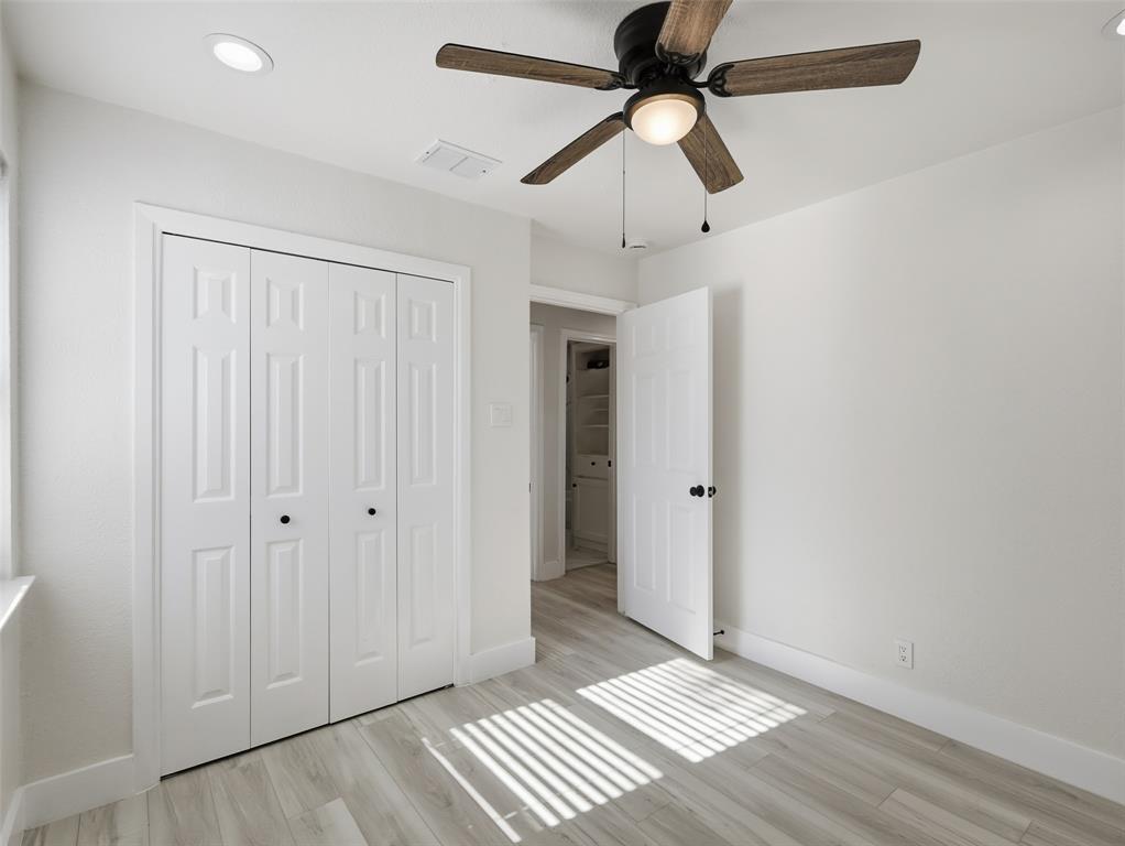 Room featuring wood-finish flooring, recessed lighting, a ceiling fan with integrated lighting, and a multi-panel closet door