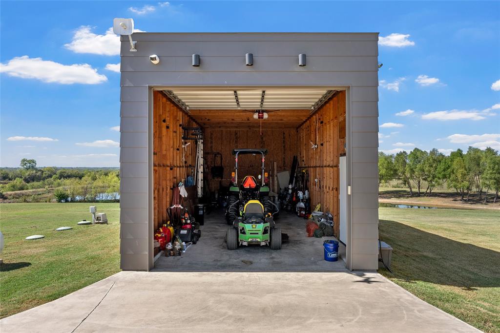 Detached structure featuring horizontal lap siding, concrete flooring, 10 foot roll down door with app and wifi enabled opener.