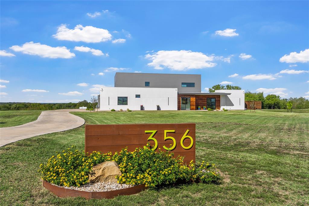 Contemporary exterior featuring white exterior, horizontal wood-finish accents, and a concrete driveway.