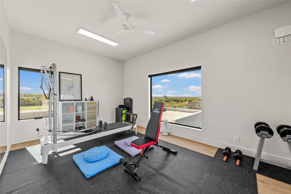 Large picture windows, wood flooring, ceiling fan, recessed lighting, and access to balcony from expansive sliding doors.