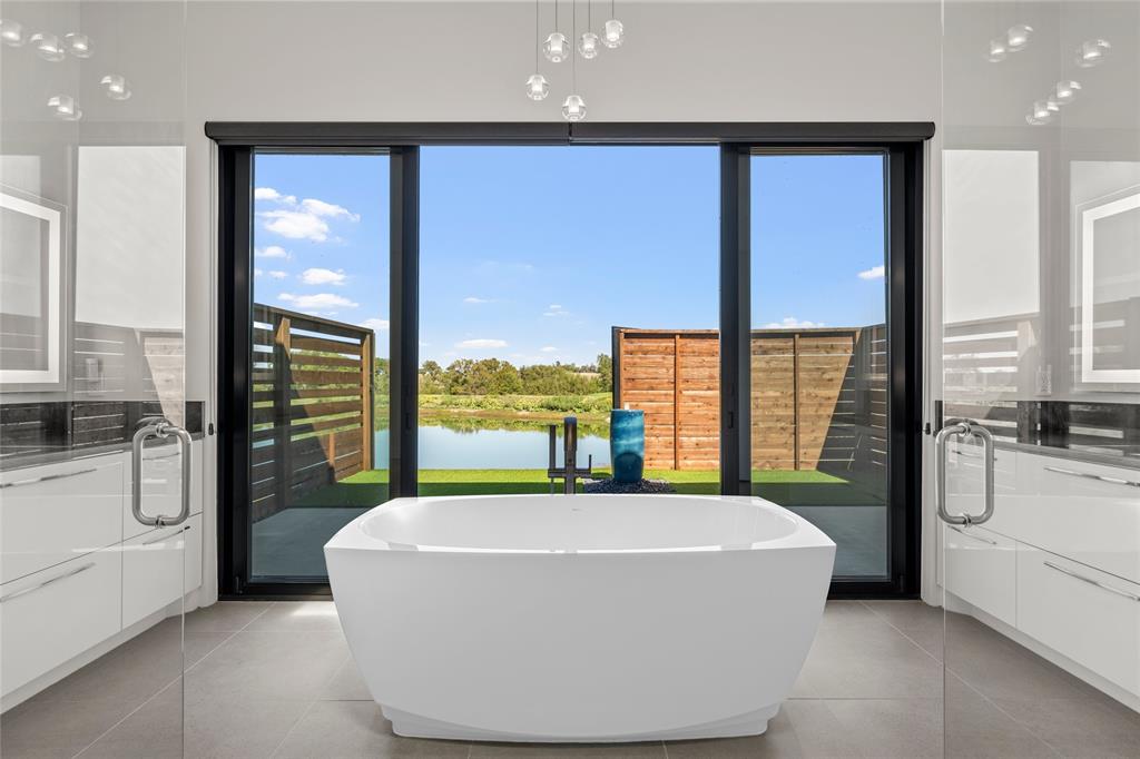 Freestanding Cryometric soaking tub, expansive glass sliding doors, high-gloss cabinetry, and 24 inch ceramic tile flooring