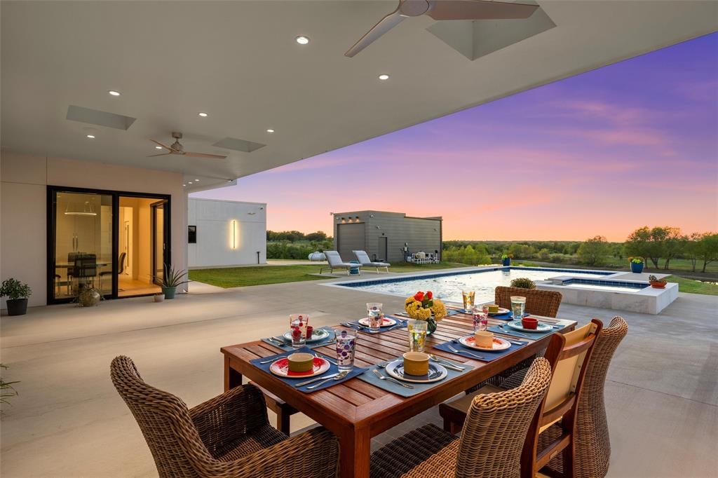 Covered patio featuring recessed lighting. skylights and ceiling fans, inground pool with an integrated spa and water features, and expansive landscape