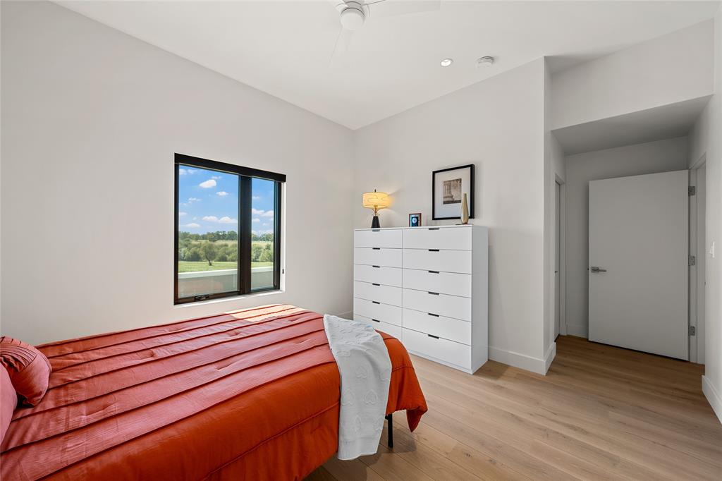 Neutral-toned walls, wood flooring, recessed lighting, ceiling fan, and egress window and large walk in closet
