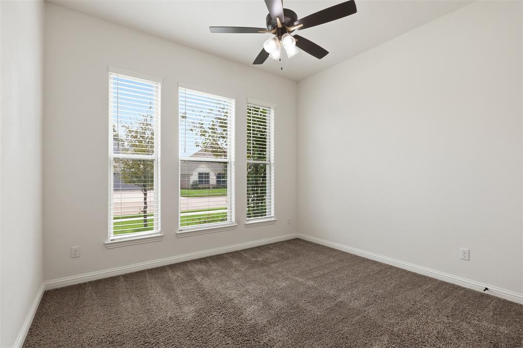 Room featuring neutral walls, carpeting, triple window configuration with horizontal blinds, and a ceiling fan with light kit