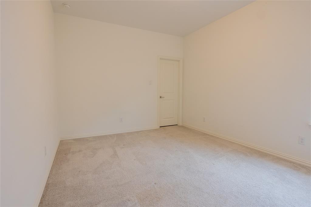 Neutral-toned wall finish, high ceilings, and plush wall-to-wall carpeting complemented by a single-panel interior door