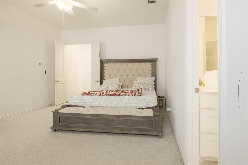 Neutral-toned carpeting, ceiling fan with integrated lighting, and double-door entry