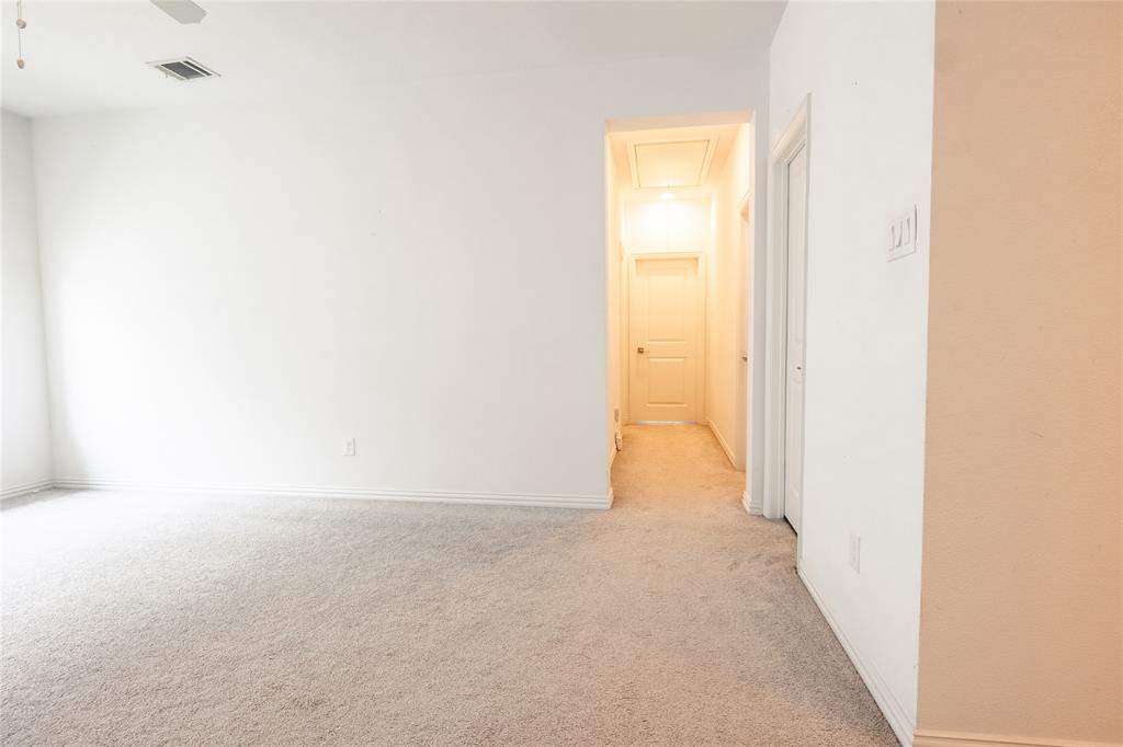 Neutral-toned carpeting, smooth-finish walls, ceiling-mounted light fixture, and interior panel door