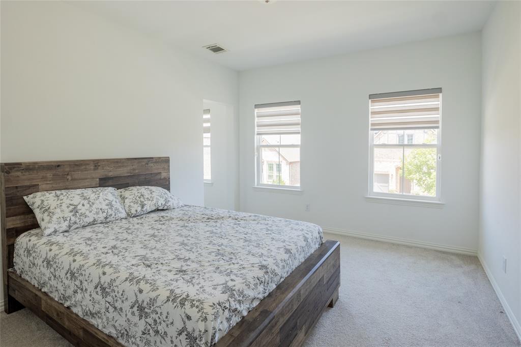 Neutral wall finishes, plush carpeting, and two windows with dual-layer privacy blinds