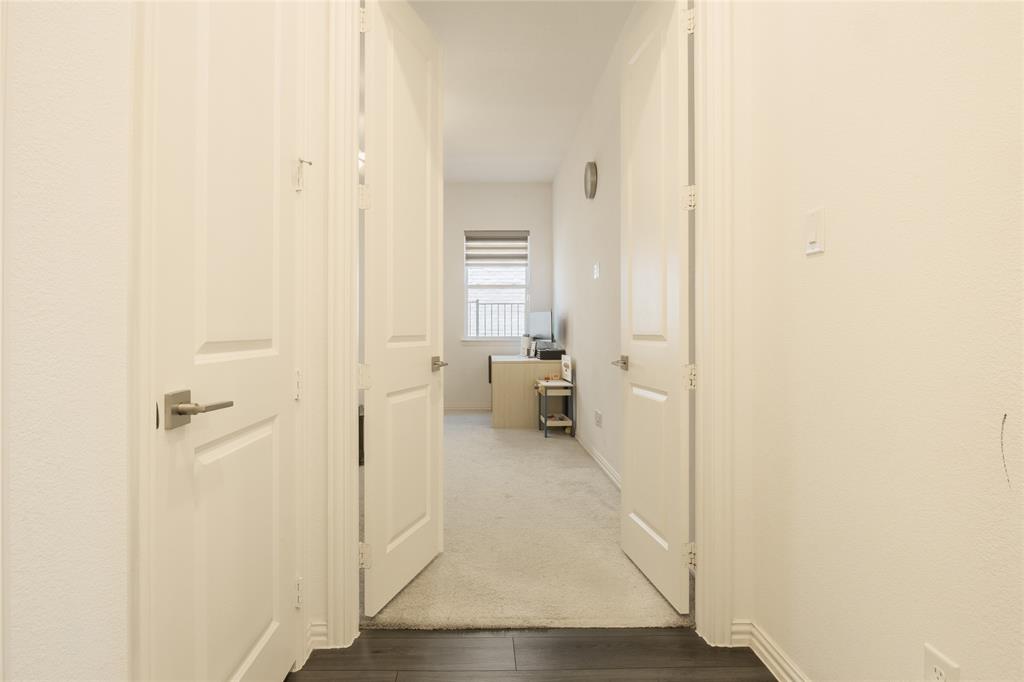 Double-panel swinging doors with satin-nickel lever hardware, neutral wall-to-wall carpeting, and wood-finish flooring