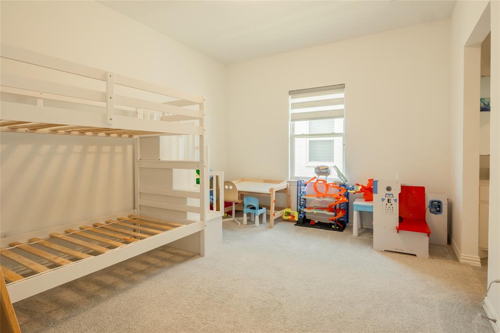 Room featuring neutral wall tones, wall-to-wall carpeting, and a window with a retractable shade