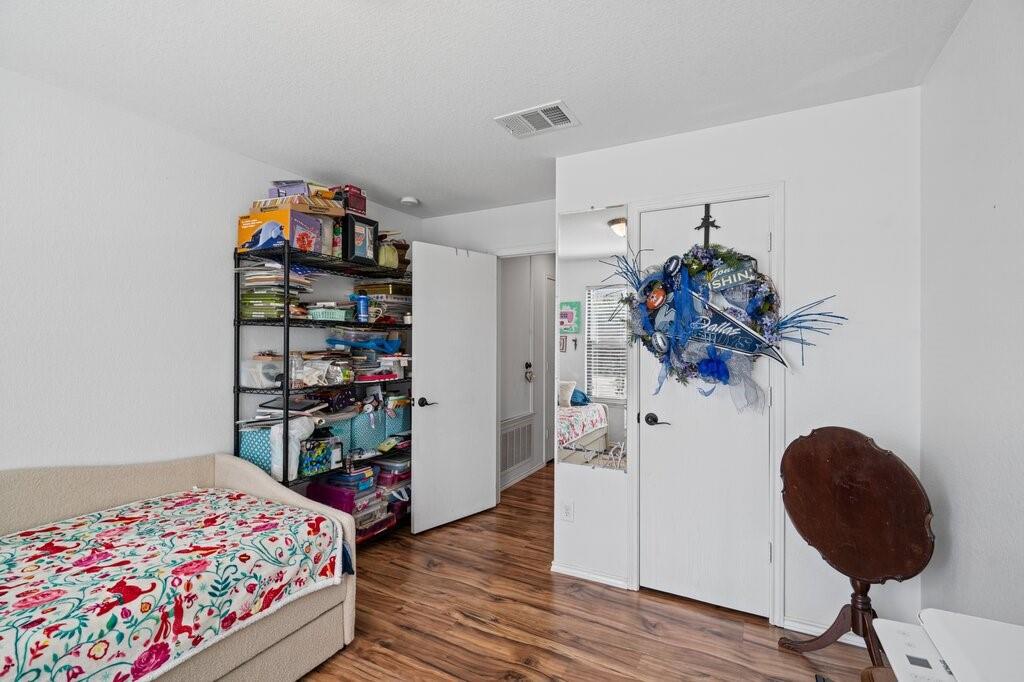 Neutral interior featuring wood-finish flooring, white walls, a flush-mount ceiling light, and a white interior door