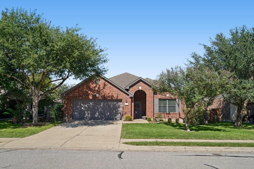 Single-story brick exterior featuring a multi-gabled roofline, an arched entryway, and an attached two-car garage Single-story brick exterior featuring a multi-gabled roofline, an arched entryway, and an attached two-car garage