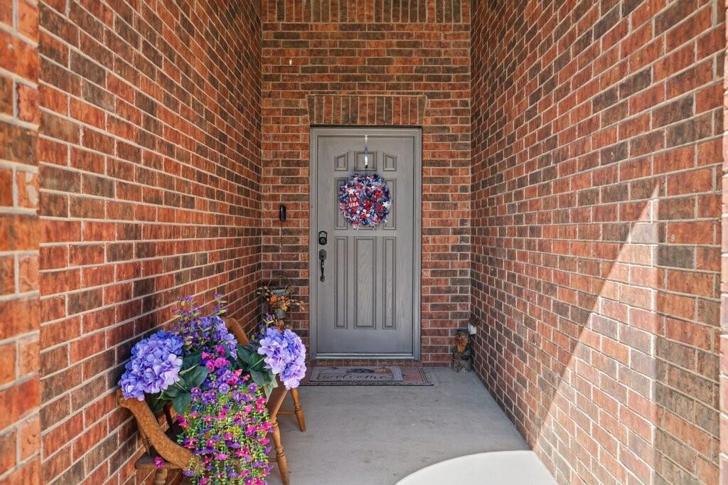 Covered entryway featuring multi-tonal brick masonry and a paneled grey entry door Covered entryway featuring multi-tonal brick masonry and a paneled grey entry door