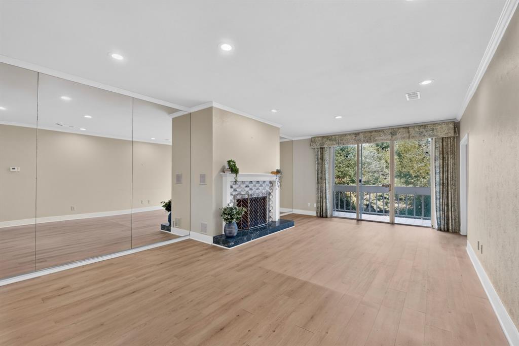Living area featuring wood-burning fireplace and sliding glass doors that open onto an exterior balcony.