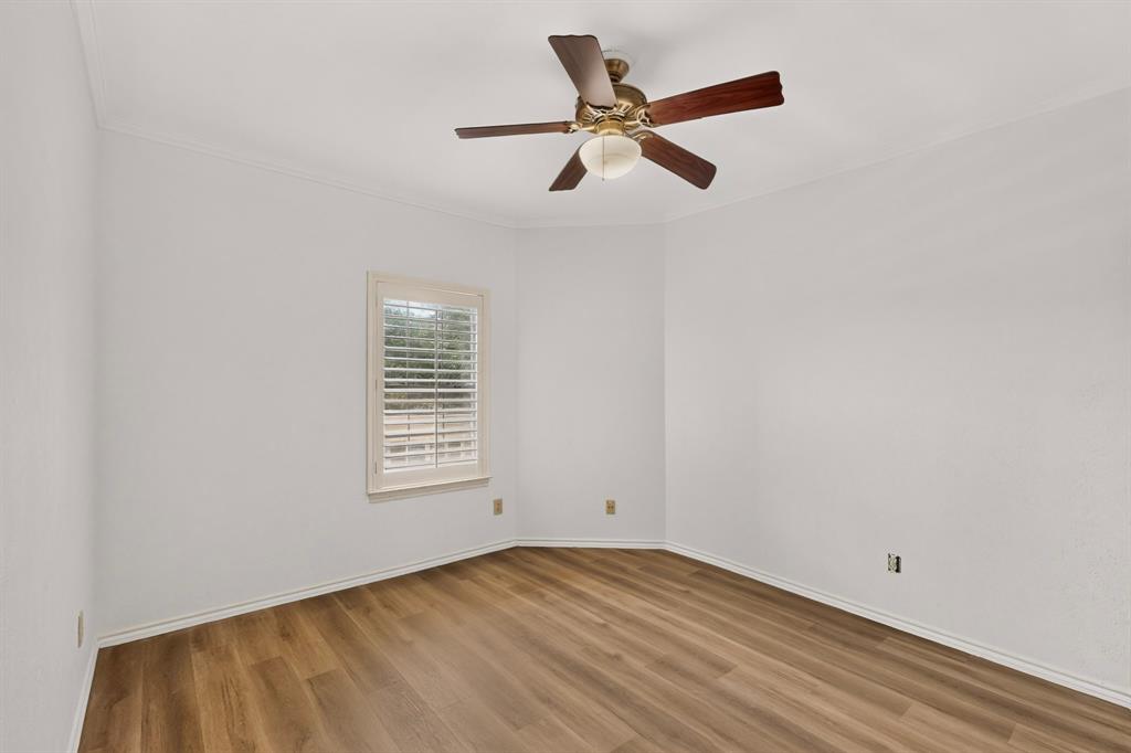 Second bedroom featuring newly installed laminate flooring and fresh paint.