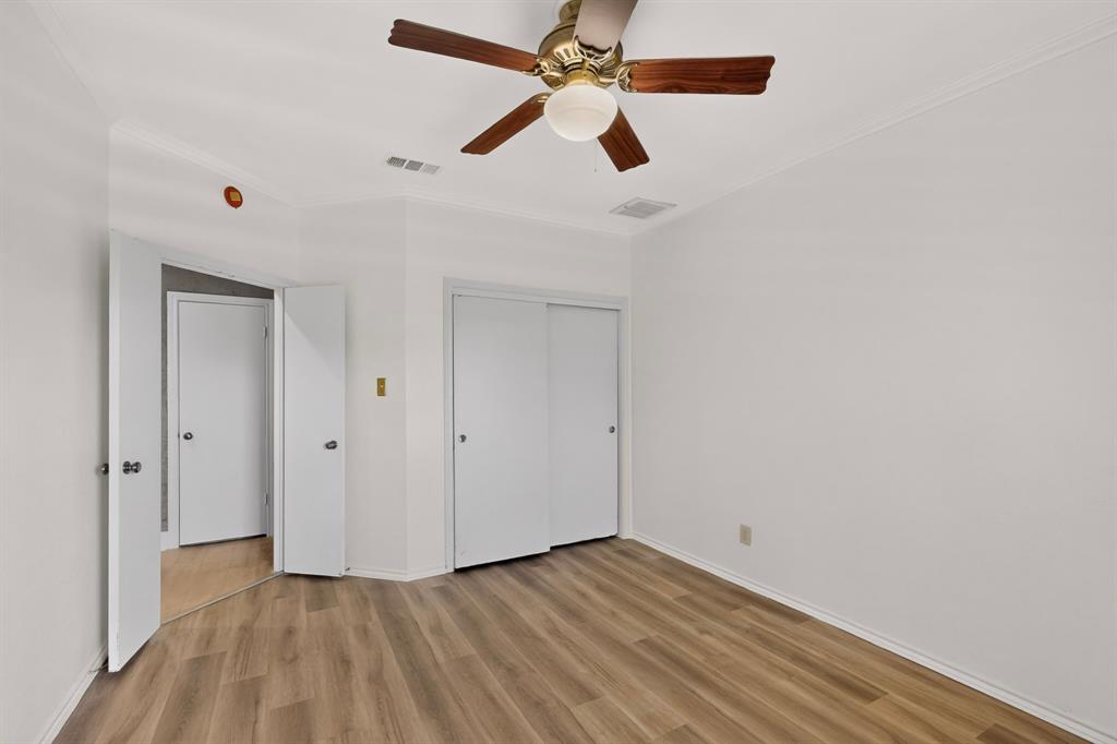 Fresh paint and newly installed flooring in the second bedroom with double sliding doors on the interior closet space.