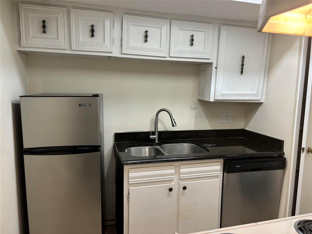 Kitchen featuring sink, white cabinets, and appliances with stainless steel finishes