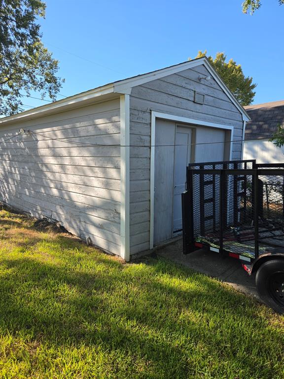 Detached garage featuring horizontal siding, a gabled roofline, and an integrated side-entry access door