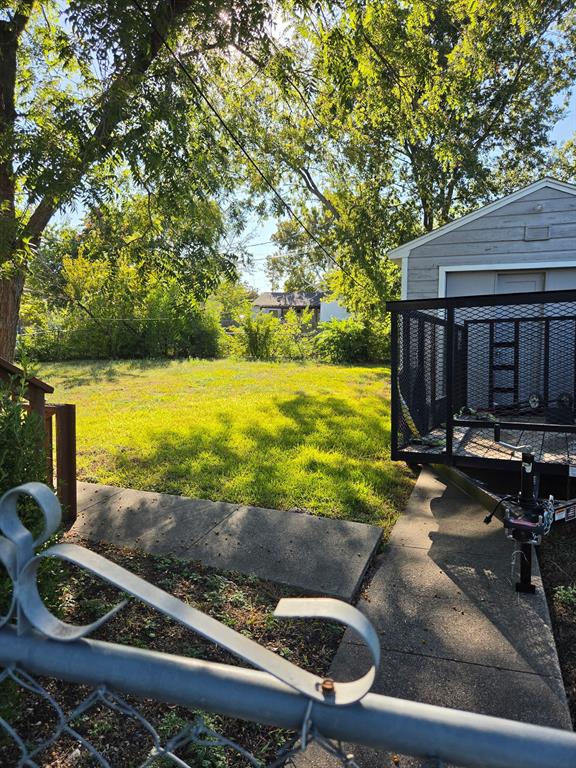 Expansive backyard featuring a level lawn, concrete walkway, and mature trees Expansive backyard featuring a level lawn, concrete walkway, and mature trees
