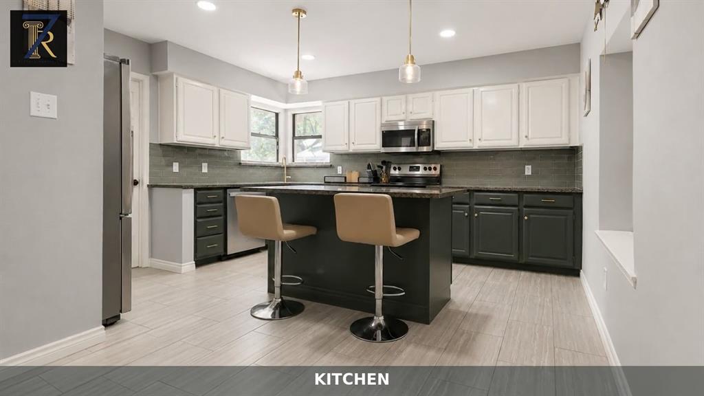 Kitchen featuring a center island, two-tone cabinetry, stainless steel appliances, tiled backsplash, and recessed lighting