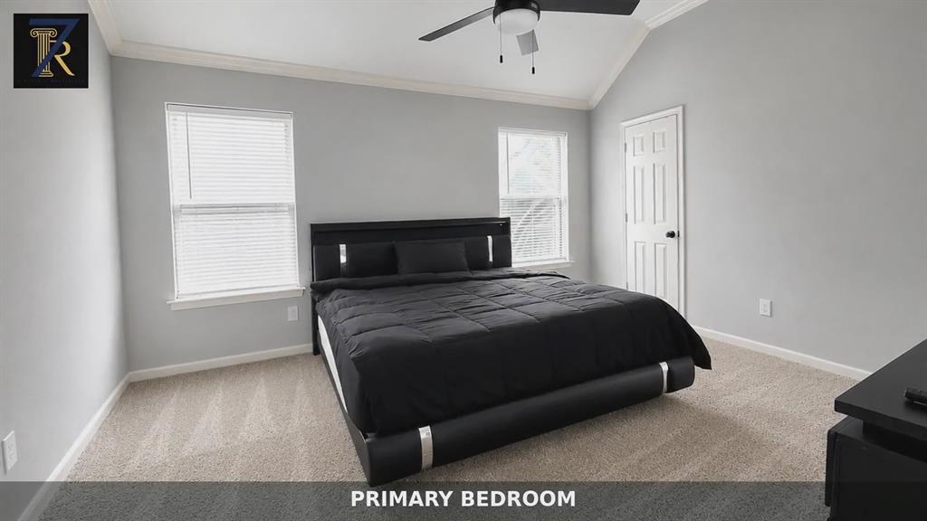 Vaulted ceilings featuring crown molding, neutral wall finishes, carpeted flooring, and a central ceiling fan