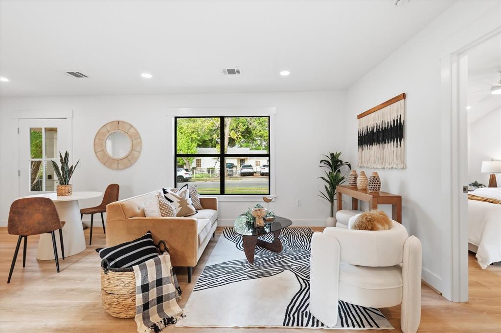 Open-concept interior featuring wood-finish flooring, recessed lighting, and a large black-framed window Open-concept interior featuring wood-finish flooring, recessed lighting, and a large black-framed window