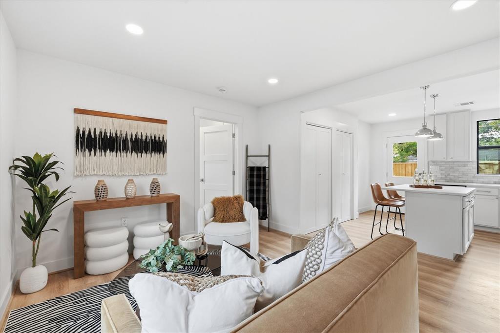 Open-concept interior featuring wood-finish flooring, recessed lighting, and a kitchen island with pendant lighting Open-concept interior featuring wood-finish flooring, recessed lighting, and a kitchen island with pendant lighting
