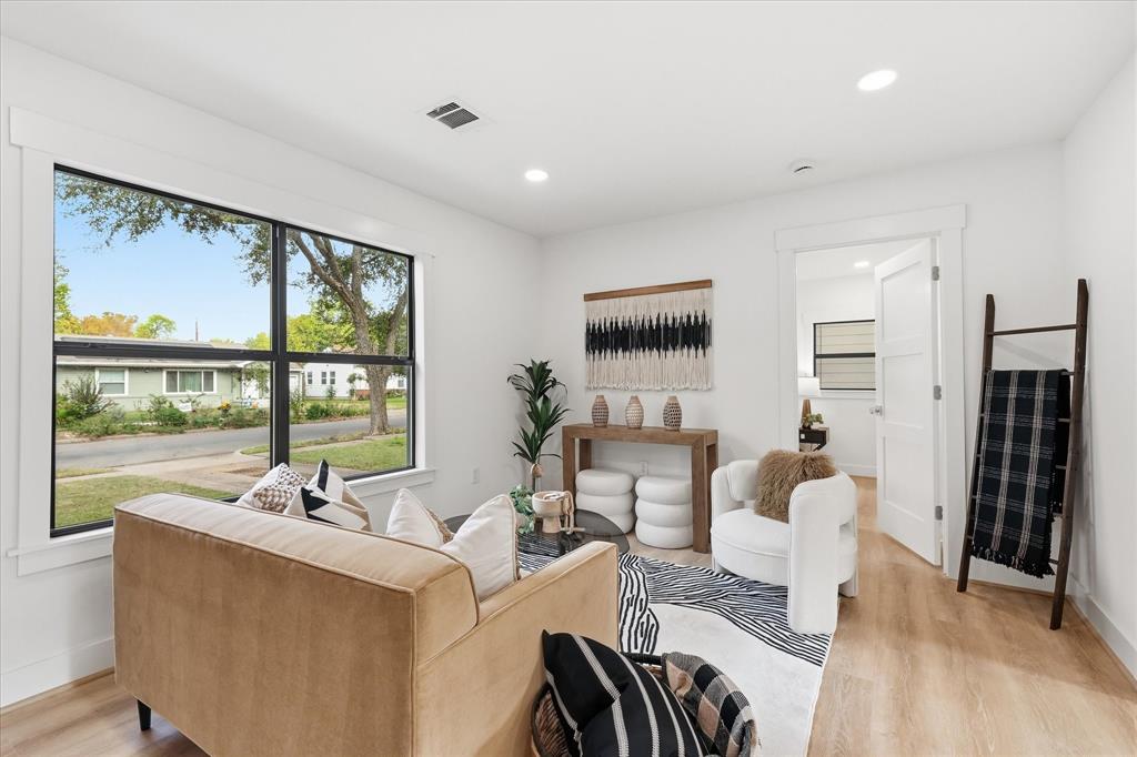Large black-framed window, wood-finish flooring, recessed lighting, and white shaker-style interior door Large black-framed window, wood-finish flooring, recessed lighting, and white shaker-style interior door