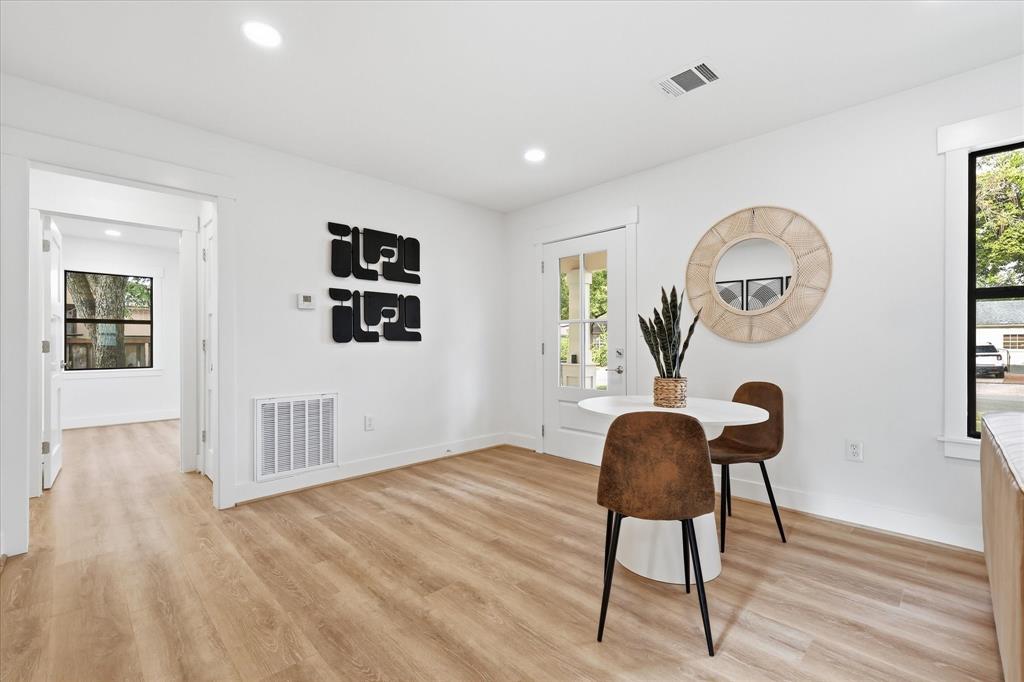 Light-filled room featuring wood-finish flooring, recessed lighting, and a glass-paneled exterior door Light-filled room featuring wood-finish flooring, recessed lighting, and a glass-paneled exterior door