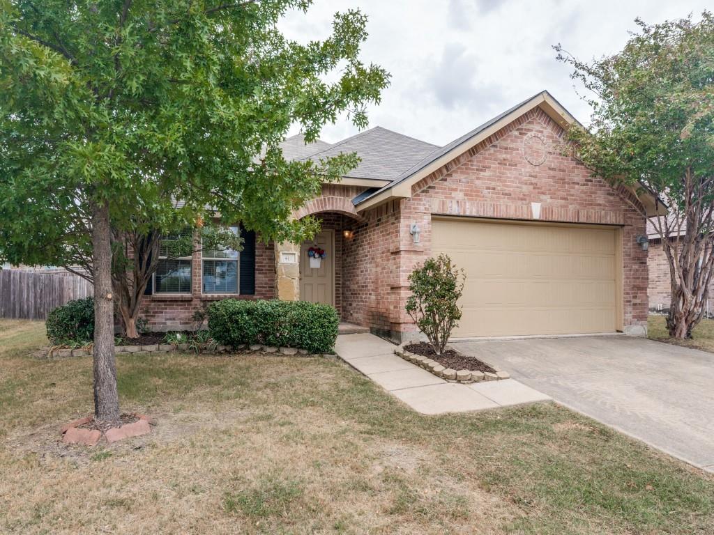 Brick single-story home with mature landscaping, attached two-car garage